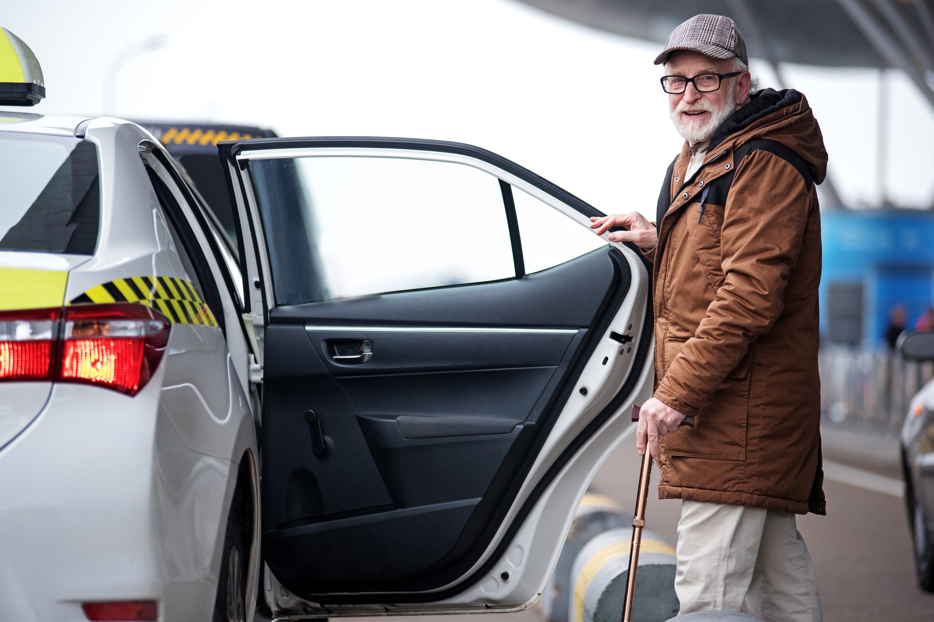Skäggig man i glasögon kommer att sätt sig i en taxi